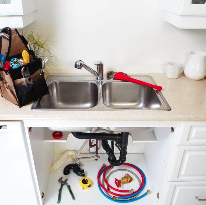 man holding hose at top of water heater