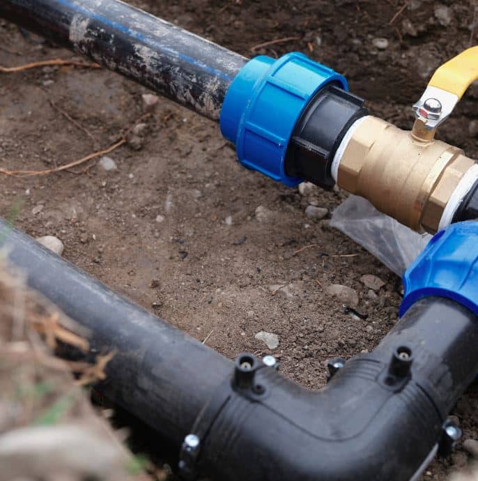 man holding hose at top of water heater
