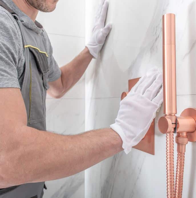 man holding hose at top of water heater