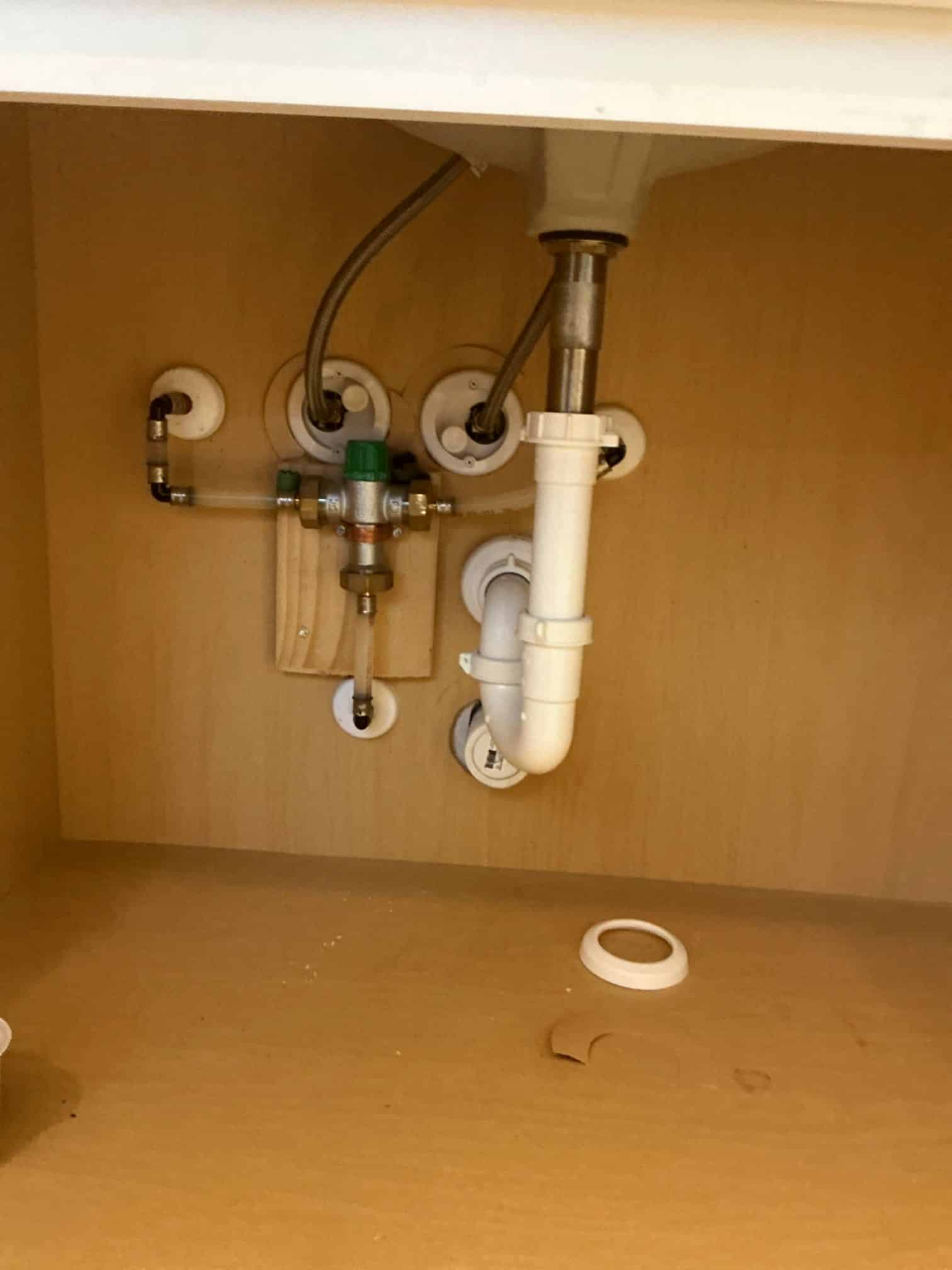 man holding hose at top of water heater