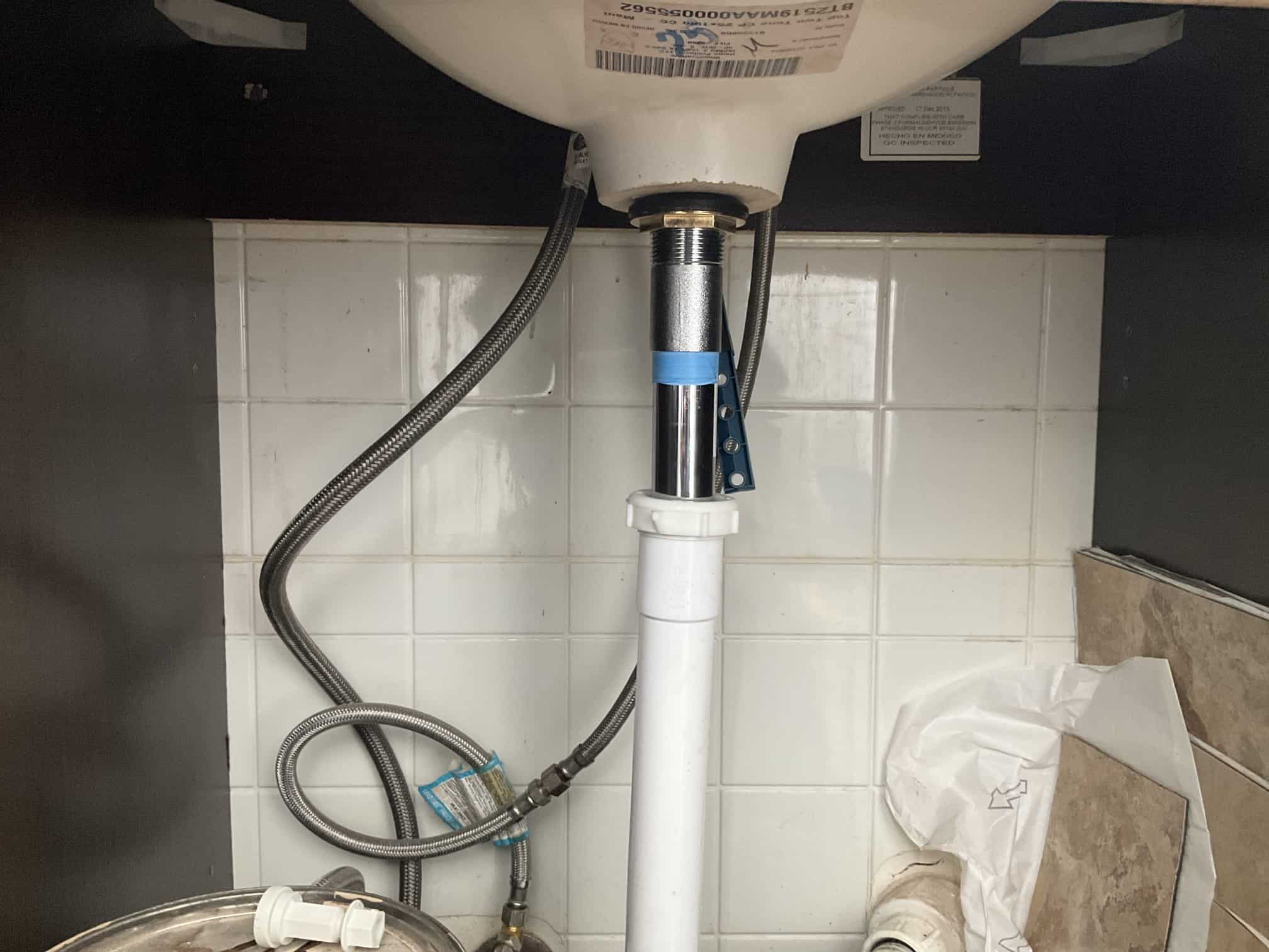 man holding hose at top of water heater
